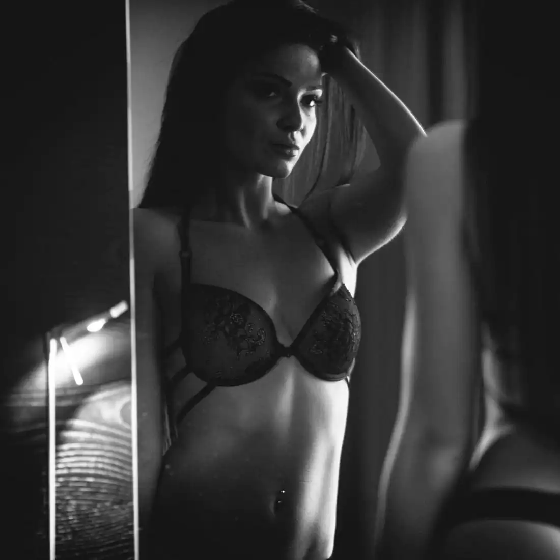 woman looking in mirror | breast augmentation in miami